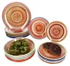 A collection of colorful, swirled patterned plates and bowls, with some pasta and donuts. Náhled obrázku produktu