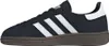 A side view of a navy blue Adidas Handball Spezial J sneaker with white stripes and a white heel tab, set against a white background. Voir les images du produit
