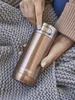 A person holding a rose gold Contigo travel mug. Produktbild-Vorschau