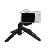 A white digital camera is mounted on a black tripod stand, isolated on a white background. Produktbild-Vorschau