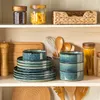 Kitchen shelves stocked with tableware and food items. Voir les images du produit