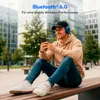 A young man is sitting on a bench outdoors, looking at his phone and wearing headphones. Produktbild-Vorschau