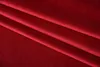 A close-up, angled view of red velvet fabric with folds. Produktbild-Vorschau