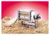 A chrome pasta maker is shown in the foreground, surrounded by dried pasta. A small bowl of eggs and flour is to the left. Anteprima dell’immagine prodotto