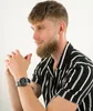 A man wearing a striped shirt and a watch, posing for a photo. Podgląd zdjęcia produktu