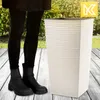 A person standing next to a planter on a wooden deck with greenery in the background. Náhled obrázku produktu