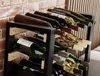 A wine rack filled with wine bottles, placed against a brick wall. Produktbild-Vorschau