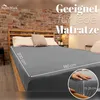 A bed with a gray fitted sheet, pillows, and a brick wall in the background. Produktbild-Vorschau