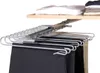 A pull-out closet organizer for pants is shown, mounted under a shelf with folded clothes. Produktbild-Vorschau