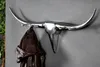 A metallic bull head coat rack mounted on a gray wall, with a brown leather jacket hanging from it. Produktbild-Vorschau