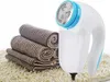 A fabric shaver and rolled towels are displayed on a textured rug. Podgląd zdjęcia produktu