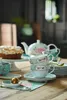 A tea set with a cake on a wooden table. Produktbild-Vorschau