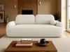 A cream-colored sofa is placed in a living room setting, with a coffee table in front of it. Voir les images du produit