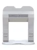 A white tile leveling clip with text on it, shown against a white background. Náhľad obrázku produktu