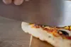 Eine Nahaufnahme einer Pizza, die gerade geschnitten wird. Mit Bildern von Pizzaschneider, Pizzaschi Produktbild-Vorschau