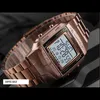 A close-up, angled shot of a rose gold digital watch with a metal band, displayed against a dark, textured background. Produktbild-Vorschau