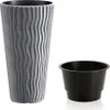 A gray planter with a wavy texture and a black insert are shown against a white background. Voir les images du produit