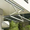 A retractable clothes drying rack is mounted on the ceiling of a balcony, with trees and a hillside visible in the background. Anteprima dell’immagine prodotto