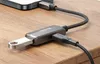A close-up shot of a Mcdodo OTG adapter connected to a smartphone and a USB-A cable, resting on a wooden surface. Náhľad obrázku produktu