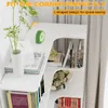 A white L-shaped bookshelf with books and decorative items. Produktbild-Vorschau