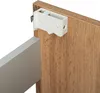 A close-up view of a cabinet hinge mechanism attached to a wooden cabinet door. Podgląd zdjęcia produktu