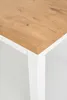 A close-up view of the corner of a table with a wood-grain top and white legs. Produktbild-Vorschau