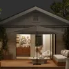 A patio scene at dusk with a large umbrella providing shade over a coffee table and seating area. Voir les images du produit