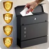 A hand is inserting a letter into a black mailbox mounted on a textured wall. Four golden shields with icons representing security, a lock and key, a diamond, and an envelope are displayed on the left side of the image. Produktbild-Vorschau