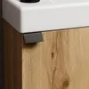A close-up view of a bathroom vanity with a white sink and a wooden cabinet. Voir les images du produit