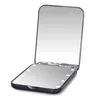 A black compact mirror with lights is open, showing its reflective surface and the lights around the edge. Produktbild-Vorschau