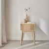 A wooden nightstand with a drawer is placed against a plain wall, with a curtain on the left. Produktbild-Vorschau