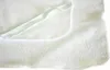 A close-up view of a white terry cloth mattress protector, showing its textured surface and a folded edge with elastic. Produktbild-Vorschau