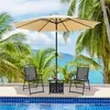 Outdoor patio set with chairs, table, and umbrella by a pool with palm trees and ocean in the background. Produktbild-Vorschau