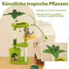 A cat tree with artificial tropical leaves, placed in a living room setting next to a sofa. Náhled obrázku produktu