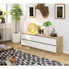 A modern living room scene featuring a dresser, plants, and decorative items. Produktbild-Vorschau