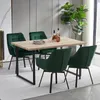 A dining set with four green velvet chairs around a wooden table, with a large plant in the background. Voir les images du produit