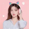 A young woman wearing cat-ear headphones against a pink background. Voir les images du produit