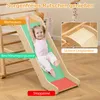 A young girl is happily sliding down a wooden slide indoors, with various zones labeled on the slide. Produktbild-Vorschau