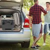 Two men are standing next to the open trunk of a car, with a cooler inside. Náhľad obrázku produktu