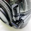A close-up view of a black and silver cleaning device, showing a hose and a nozzle attachment. Voir les images du produit