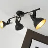 A black metal track light fixture with three adjustable spotlights is mounted on a white ceiling. Produktbild-Vorschau