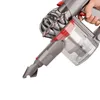 A hand holding a cordless vacuum cleaner. Produktbild-Vorschau