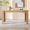 A light brown wooden dining table is shown in a well-lit room with a decorative wall and a rug. Náhled obrázku produktu