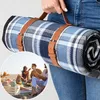 A person holding a rolled-up picnic blanket with leather straps, and a circular inset image showing people having a picnic on a beach. Anteprima dell’immagine prodotto