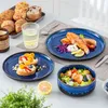 A table setting with a breakfast spread and a meal, featuring blue ceramic plates and bowls. Voir les images du produit