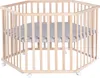 A hexagonal wooden playpen with a gray padded mat inside, shown from a slightly elevated angle against a white background. Produktbild-Vorschau