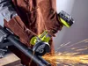 A person wearing protective gear is using a cordless angle grinder to cut a metal pipe, creating sparks. Produktbild-Vorschau