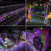 A collage of four images showing colorful LED net lights used for decoration in various outdoor settings, including stairs, trees, a patio with furniture, and a wooden structure. Produktbild-Vorschau