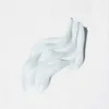 A swatch of white cream is shown on a textured white background. Náhľad obrázku produktu
