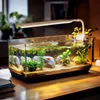 A well-lit aquarium with small fish and plants, placed on a wooden desk. Náhled obrázku produktu